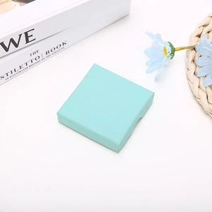 Close-up of mint green square jewelry box with elegant textured paper surface for gifts