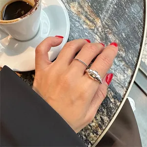 925 silver croissant ring set on model's hand next to a coffee cup on marble table