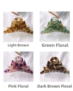 Detail view of acetate bow hair claws in floral patterns and brown tortoise colors