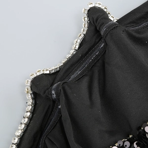 Détail de paillettes étincelantes et de strass en cristal sur une robe de soirée noire