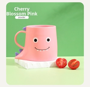 Close-up of pink dinosaur cartoon tooth mug with handle on bright green background