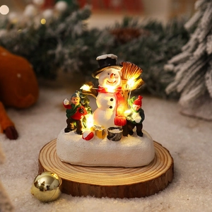 Luminous Christmas scene with snowman and child on a wooden base with warm LED lights