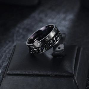 Macro view of black rotatable spinner ring with Roman numerals and chain detail