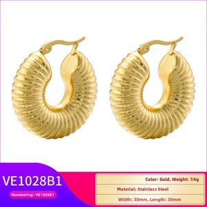 Macro view of gold-plated stainless steel thick hoop earring with spiral twist texture