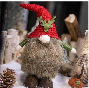 Close-up of a plush Christmas gnome with red knitted hat and green reindeer antlers