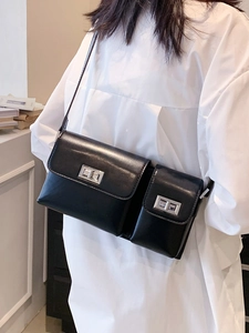 Minimalist black leather baguette bag with dual compartments and silver metal turn-lock closure