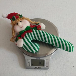 Detailed view of striped Christmas elf candy cane plush weighing 32.3g on a digital scale