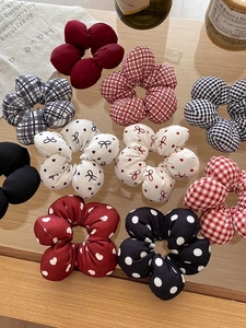 Flat lay of fabric scrunchies with red, black, and white checkered and polka dot patterns