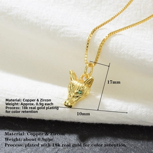 Macro detail of 18k gold-plated wolf head pendant featuring sparkling green zircon eyes