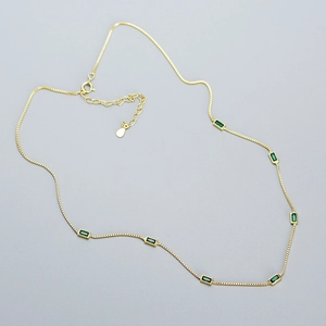 Detail of 925 silver gold chain necklace with rectangular green emerald stones