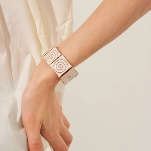 Close-up of vintage enamel square link bracelet with rose gold spiral pattern