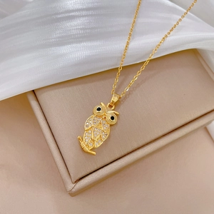 Elegant gold owl pendant necklace with sparkling rhinestones on a silk background