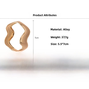 Macro shot of gold-plated wavy irregular open bangle with weight and size specifications