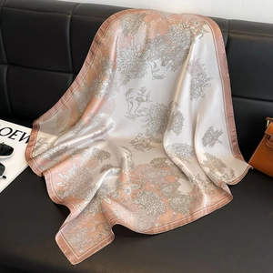 Pink floral square silk scarf with elegant daisy prints on a luxury leather surface