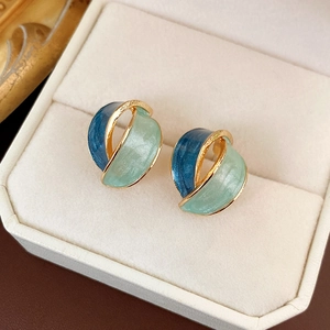 Vintage enamel flower stud earrings with blue and green abstract design in a jewelry box