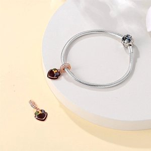 Detailed view of silver snake chain bracelet featuring a heart-shaped enamel charm