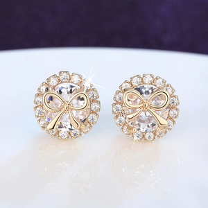 Macro view of gold bow earrings featuring round cubic zirconia and pavé halo details