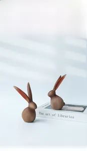 Détail de figurines lapin en résine avec texture mate sur un fond bleu clair