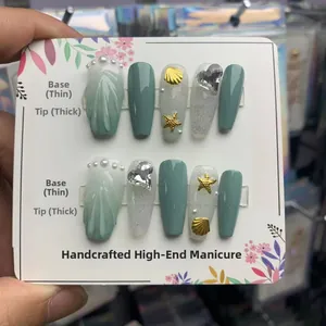 Détail de faux ongles faits main thème océan avec étoiles de mer et coquillages