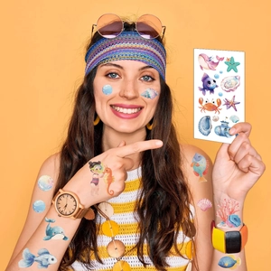 Kids ocean animal temporary tattoos featuring whale and seahorse designs on a model