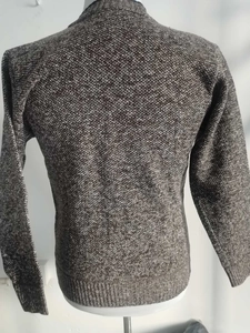 Detailaufnahme des Strickpullovers mit grau melierter Textur und Rippbündchen