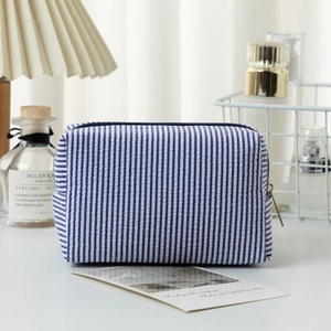 Blue and white striped seersucker cosmetic bag with zip closure for travel toiletries