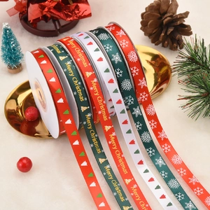 Close-up of festive Christmas ribbons with Merry Christmas patterns on a golden tray