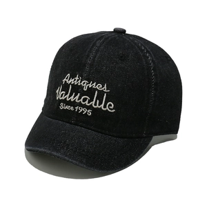 Detail of black denim baseball cap with white script embroidery and short brim