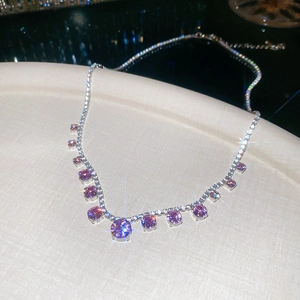 Detailed macro view of sparkling pink zircon circular pendants on silver chain necklace