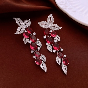 Detail of silver leaf earrings with red oval stones and long sparkling tassels