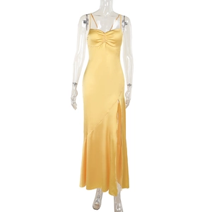 Detail of elegant yellow satin dress featuring a high side slit and refined draping fabric