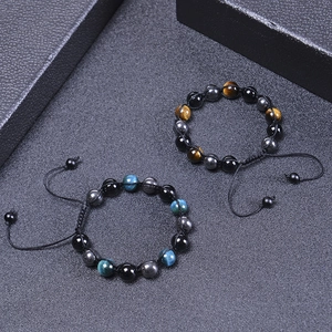 Detailansicht der gewebten Tigerauge- und Hämatit-Armbänder auf schwarzem Hintergrund