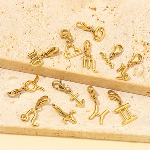 14K gold plated zodiac pendants set with lobster clasps on elegant stone background