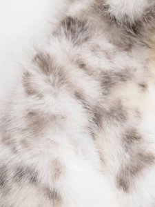 Macro shot of faux fur fabric with white and brownish leopard print texture
