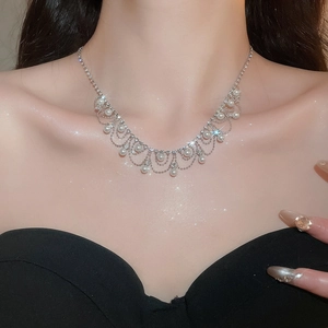 Close-up of elegant silver tassel necklace with pearls and rhinestones on model