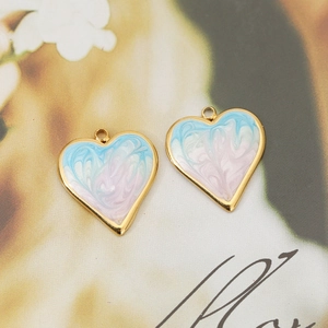 Macro shot of two heart charms with pink and blue marble textures on a magazine