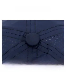 Close-up of navy blue baseball cap showing top button stitching and breathable laser holes