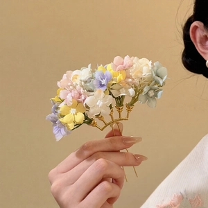 Detailed close-up of handmade fabric flower hair pin with elegant gold metal base design