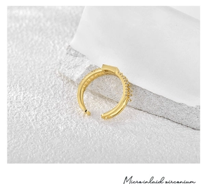 Macro di anello placcato oro 18K con zirconi micro-incastonati su pietra bianca pura