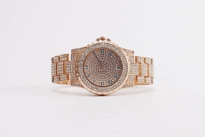 Macro detail of rose gold watch dial with Roman numerals and full crystal pavé setting