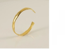 Macro detail of 18K gold bamboo-shaped C-bracelet with a flexible adjustable design