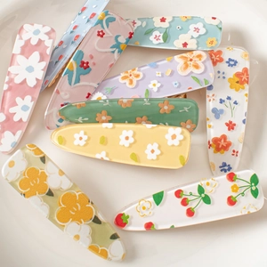 Detailed view of colorful acrylic flower and strawberry hair clips with glitter