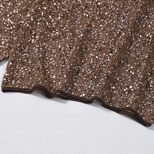 Detailed close-up of champagne gold sequins on brown mesh fabric with hem stitching