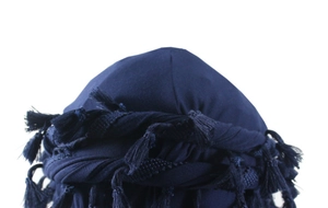 Close-up of navy blue satin-lined turban cap featuring twisted rope and fringe tassel details