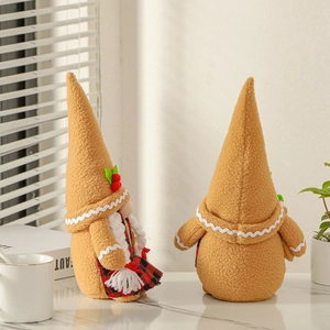 Pair of festive gingerbread gnome plush ornaments with plaid aprons in a cozy home setting
