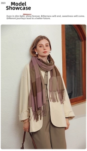 Detail of plaid tassel scarf with brown and pink blocks styled on beige winter coat