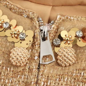Elegant gold sequin flower details and textured buttons on a beige tweed jacket set