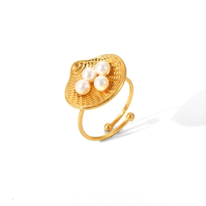 Detailed shot of golden shell-shaped ring featuring four white pearls on an open band