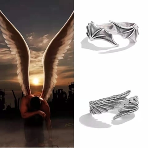 Detail view of retro Thai silver couple rings featuring angel and demon wing designs