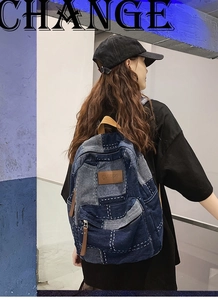 Detail showing vintage washed denim patchwork with rugged white stitching and front pocket